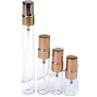 Glass perfume sample atomisers with gold caps on white background